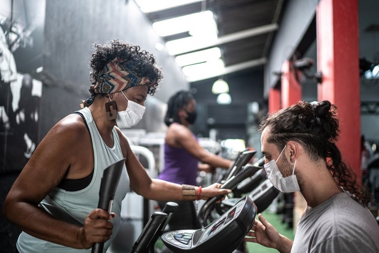 Woman working out in gym with mask