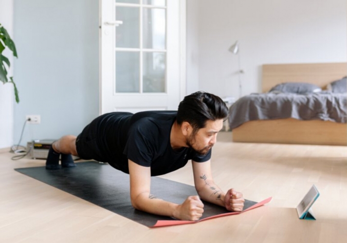 Man doing yoga at home watching a video
