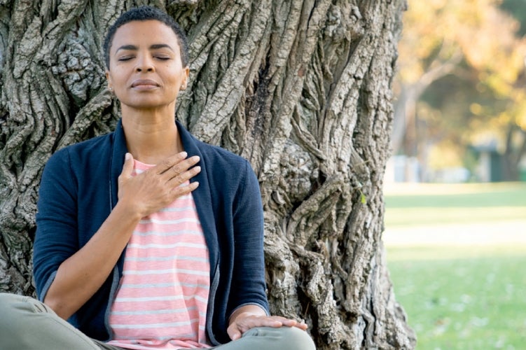 Woman meditating under a tree