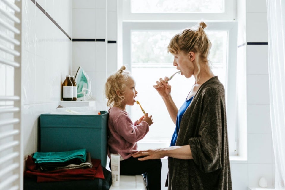 Mother and child brushing teeth