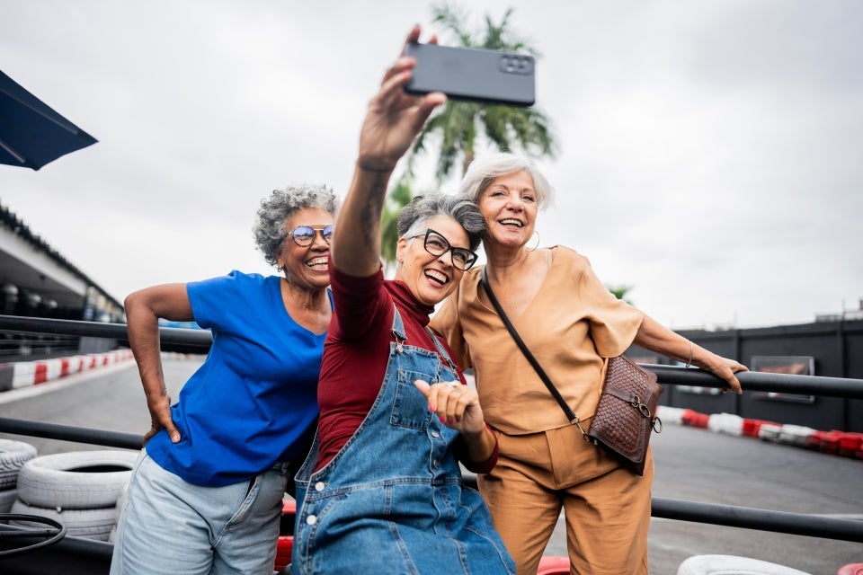 Three retirees taking a group selfie. 