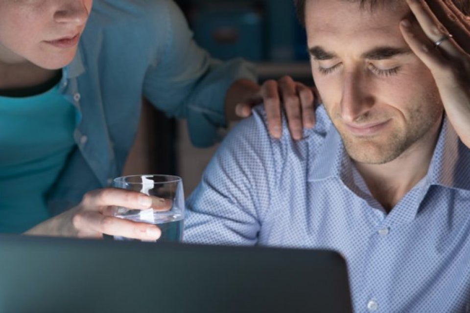 Person with a headache being offered medicine