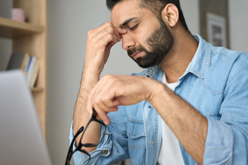 Person with tired eyes at a computer