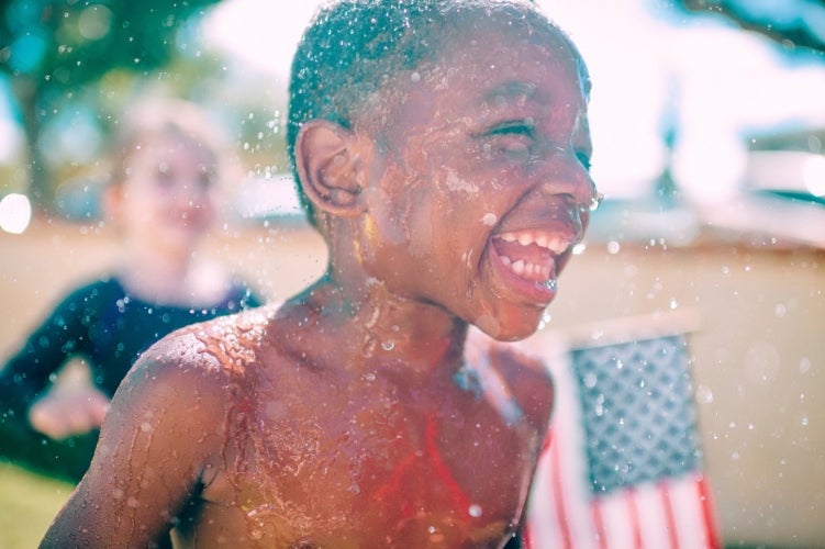 Kid playing in sprinkler