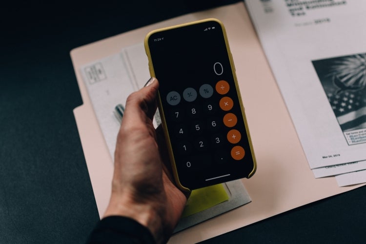 A person using a calculator when working on tax forms